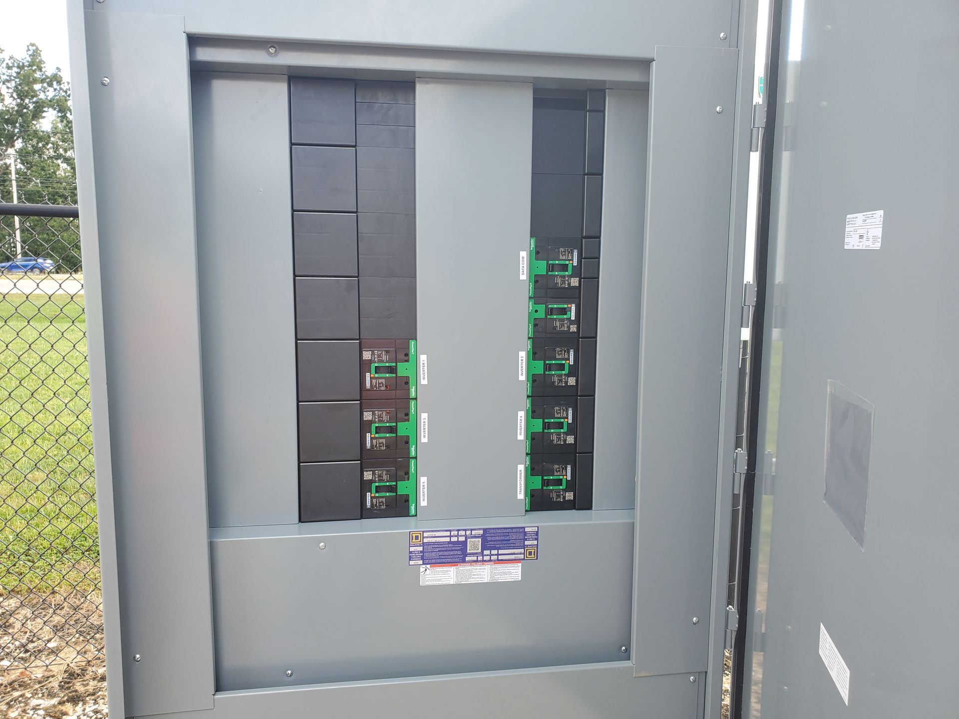 Electrical panel junction box with circuit boards, wires, and connectors, mounted outdoors.