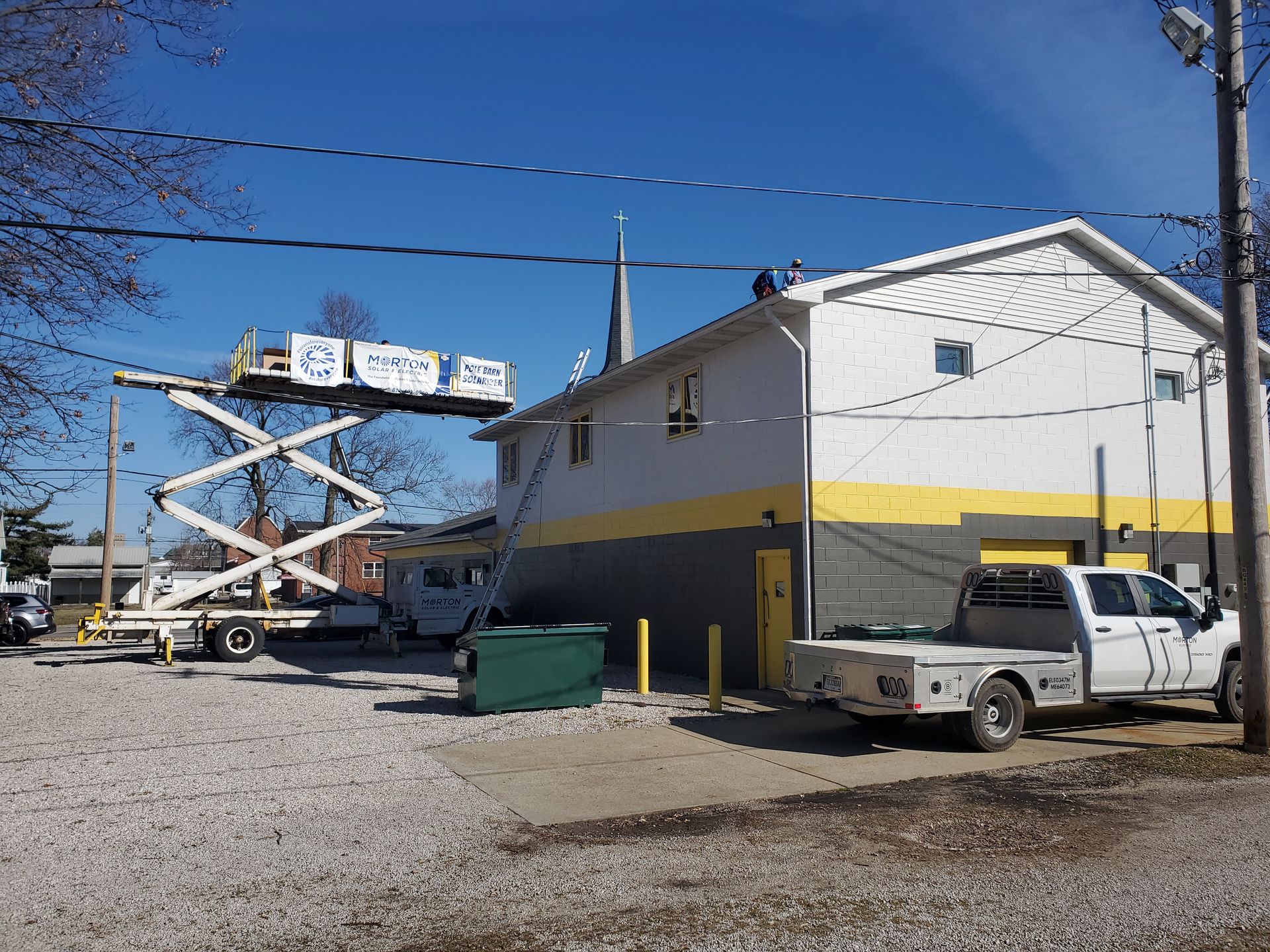 A crane lifts a Morton Electric worker to work on the roof