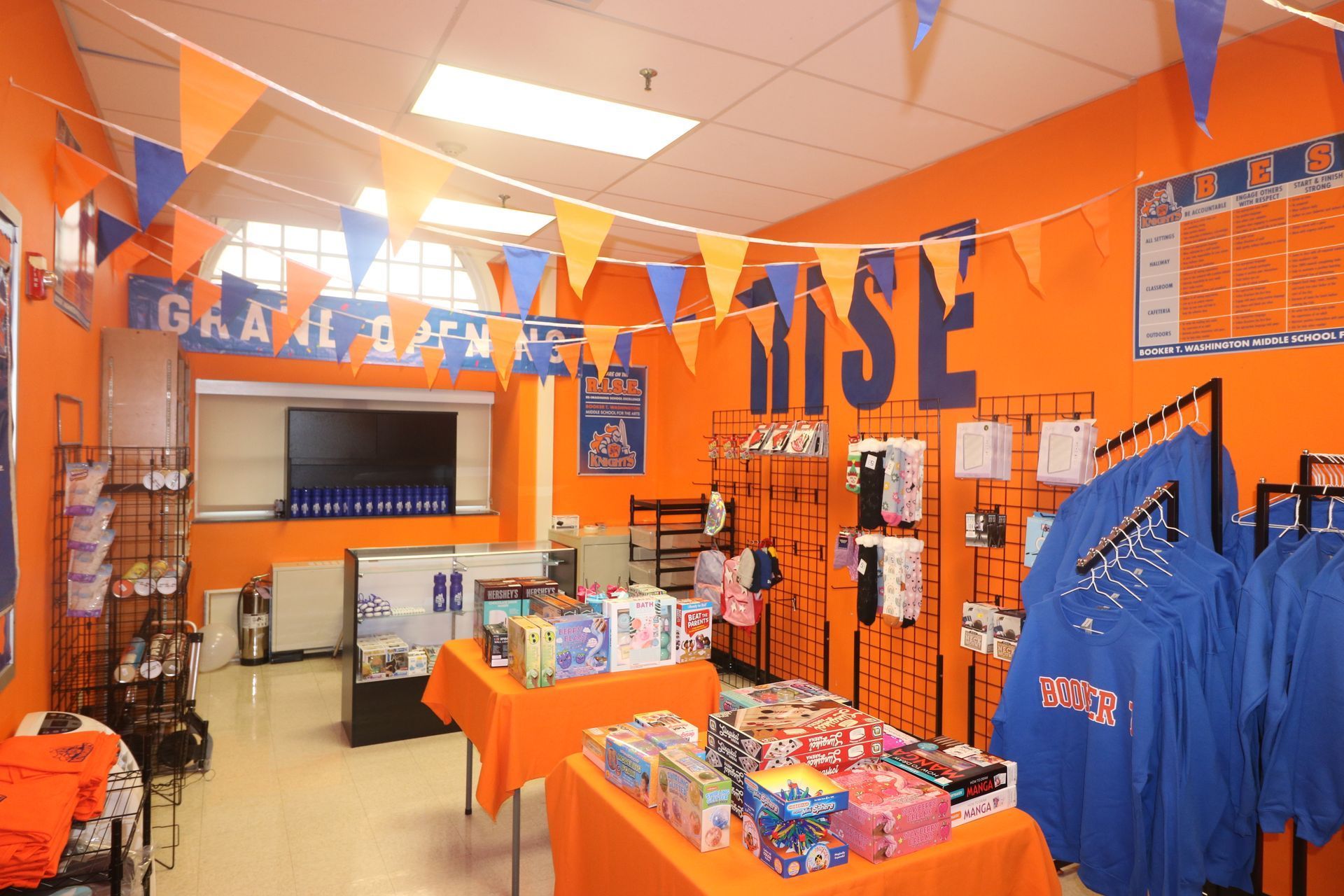 Orange-walled store with blue and orange merchandise, pennant flags, and displays.