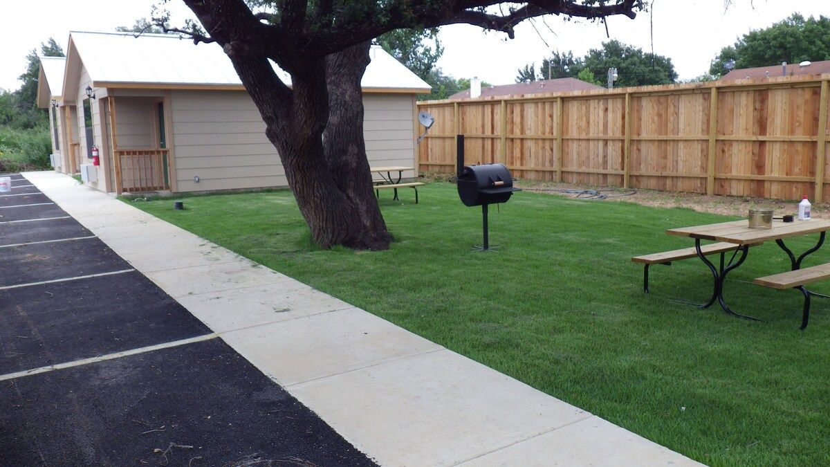 A fenced in yard with a picnic table and a mailbox