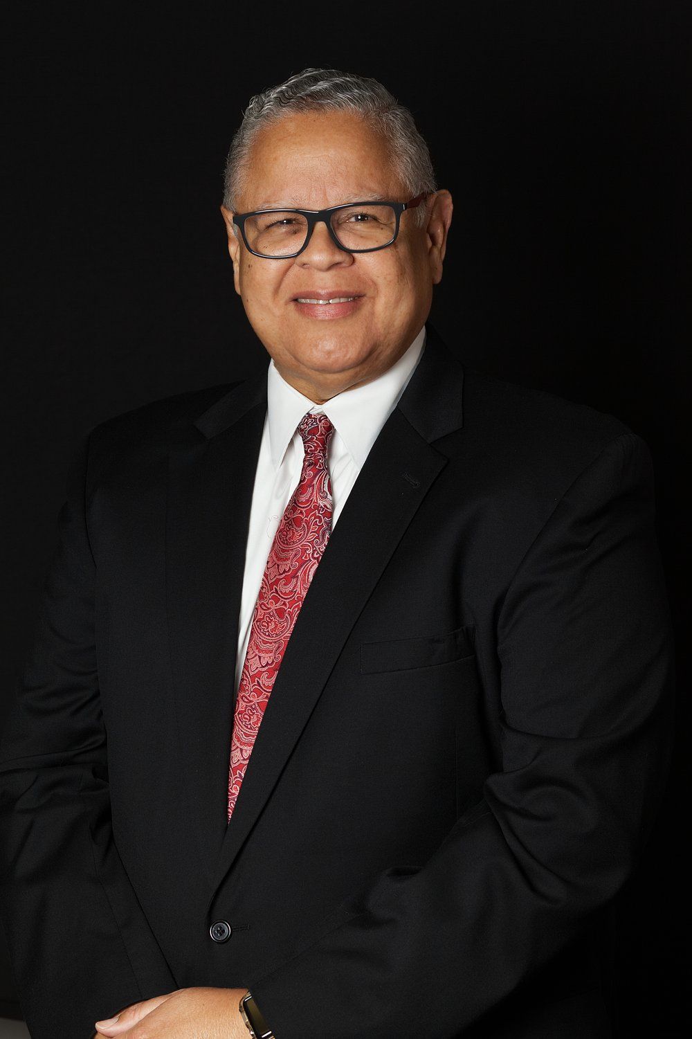 A man in a suit and tie is smiling for the camera.