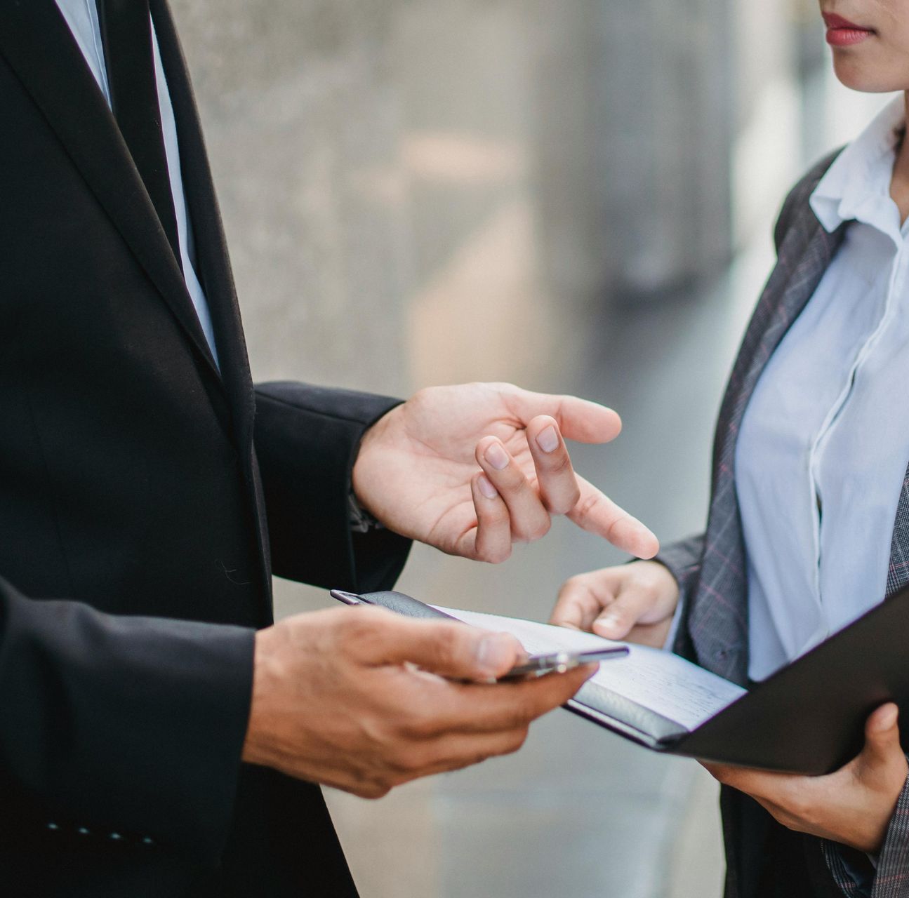 A man and a woman are looking at a cell phone.