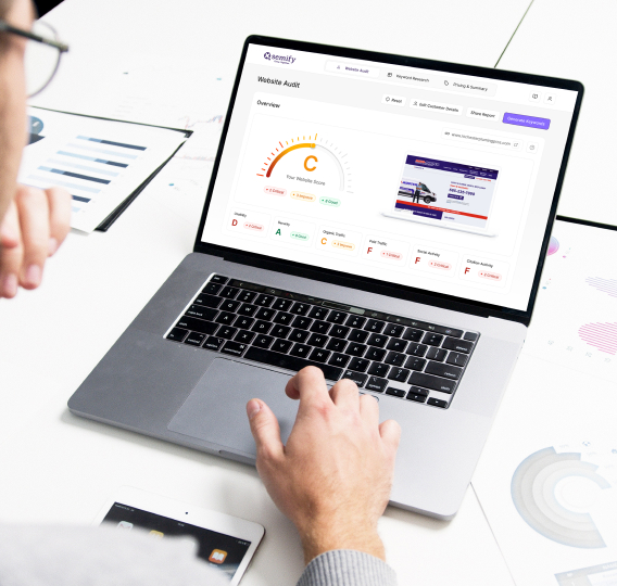 Hands using a silver laptop showing an analytics dashboard with charts and metrics