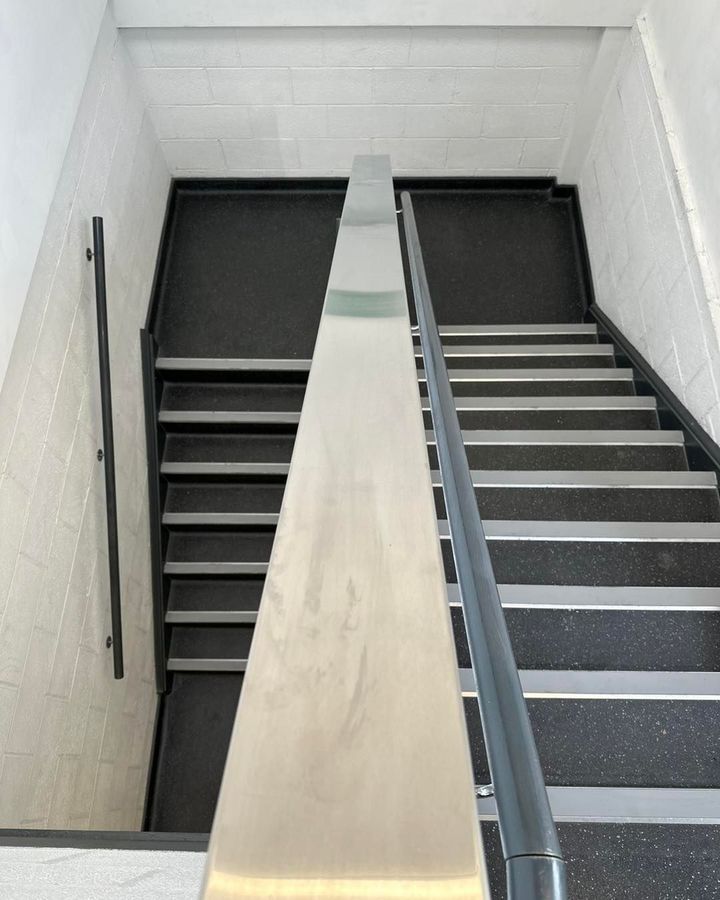 Black stair nosings fitted to a flight of stairs in a commercial building