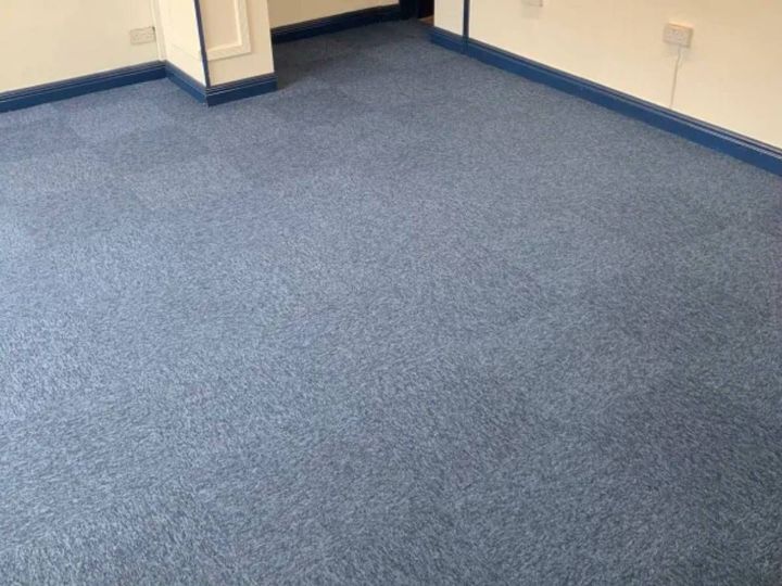 Commercial carpet tiles being installed in a Derby business