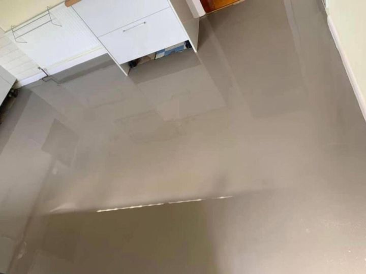 Levelling compound poured across a kitchen floor before new flooring is fitted