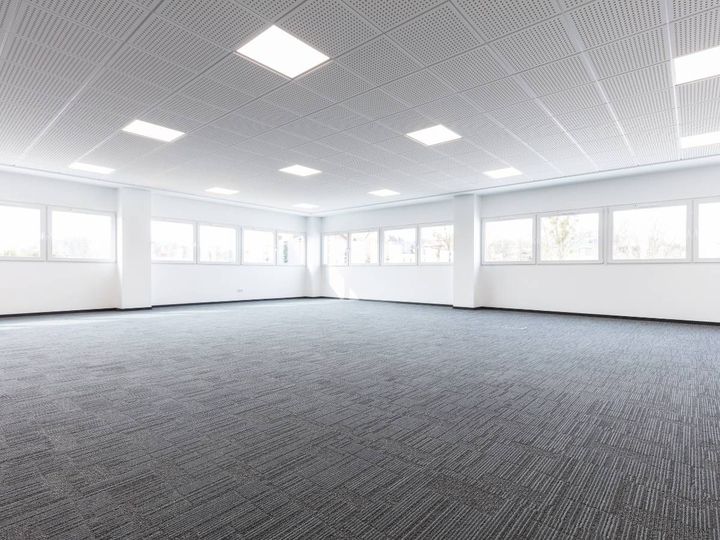 Grey linear carpet tiles across a large empty open-plan office