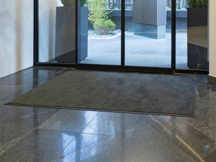Loose-lay entrance mat inside a glass entrance