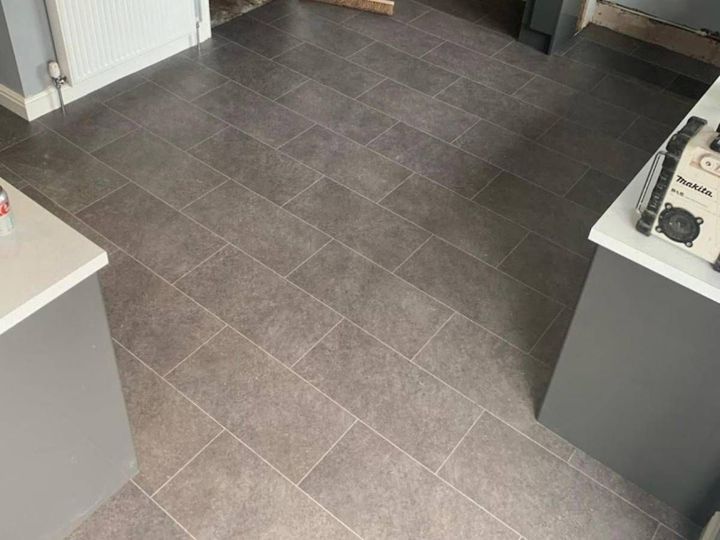 Rectangular luxury vinyl tiles with inlay strips laid to look like ceramic tiles