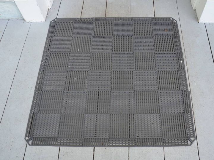 Grey rubber door mat with an open grid pattern