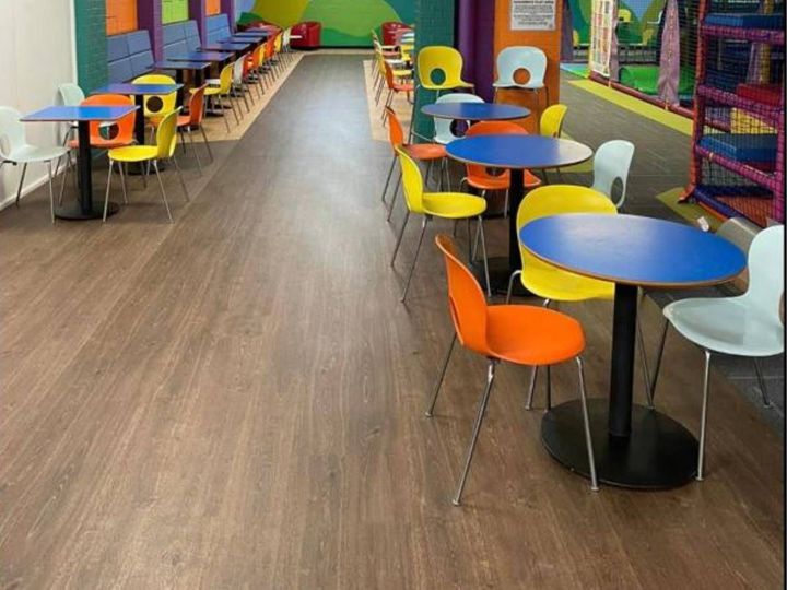 Wood-effect vinyl flooring under tables and chairs in a dining area