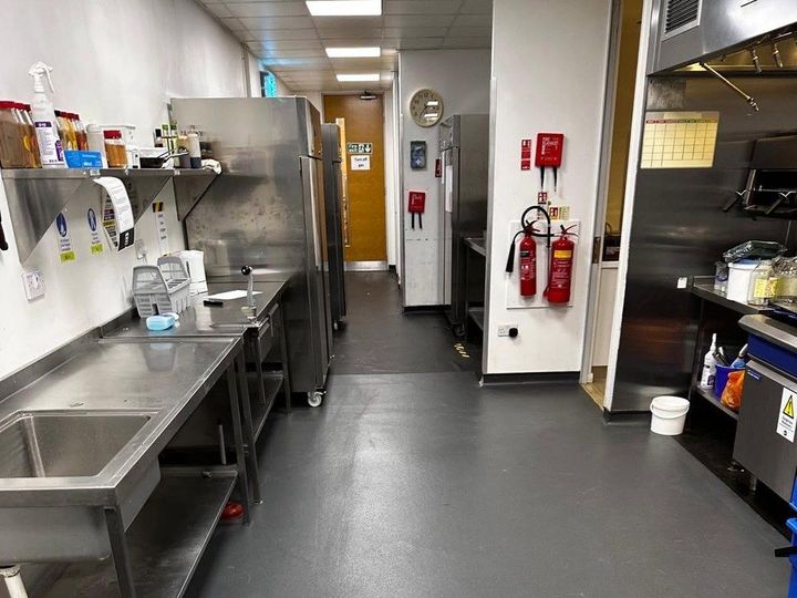 Grey safety vinyl flooring in a commercial kitchen preparation and wash-up area