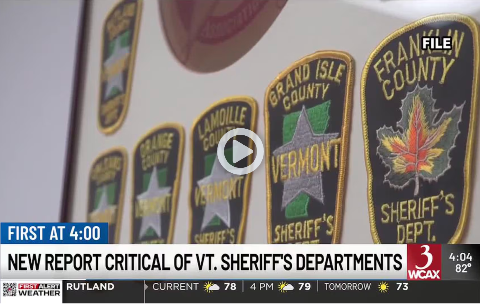 Sheriff department patches displayed on wall, with news banner about critical Vermont sheriff reports
