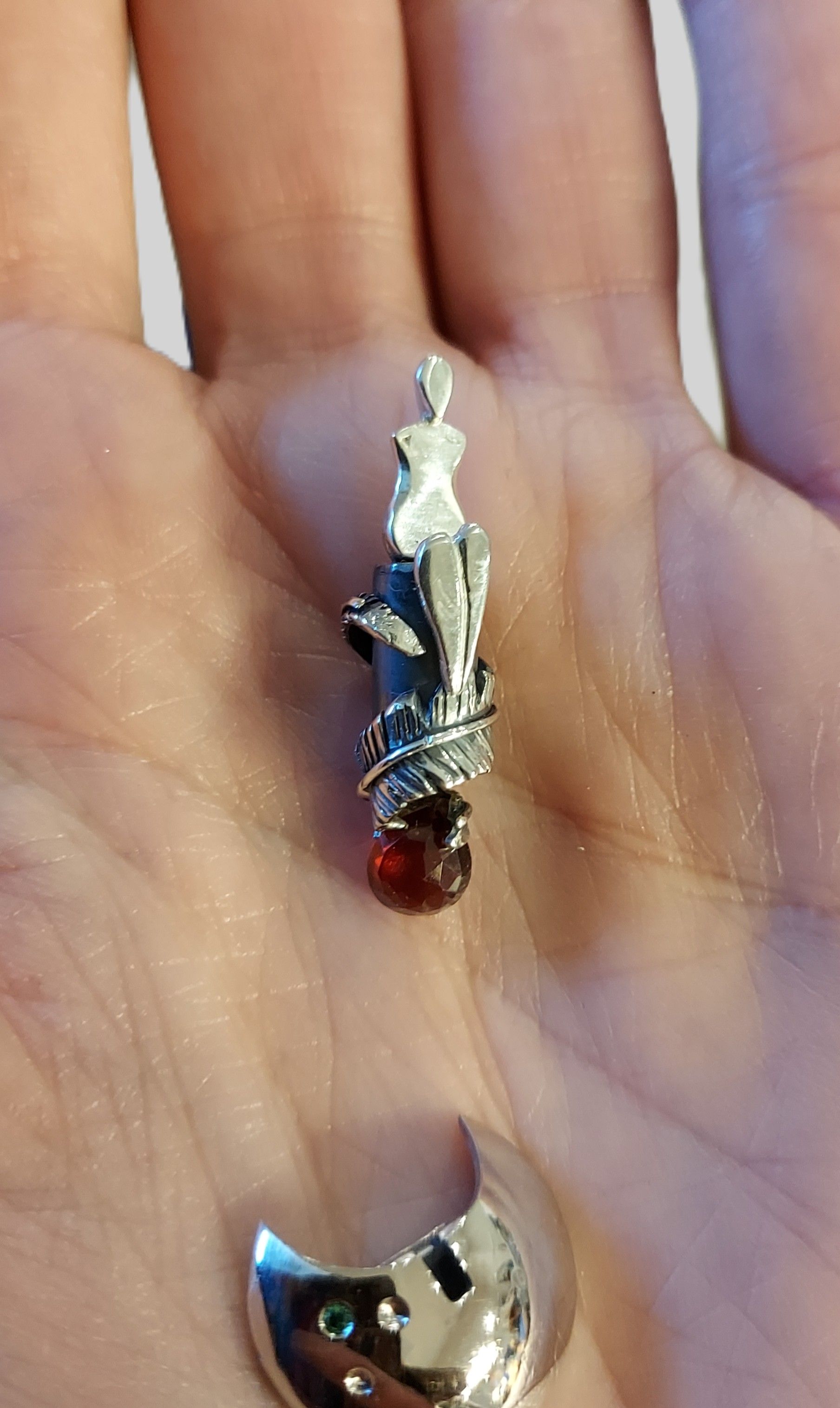 Vrouw-veerhanger nog mat zilver met veer gewikkeld om bak