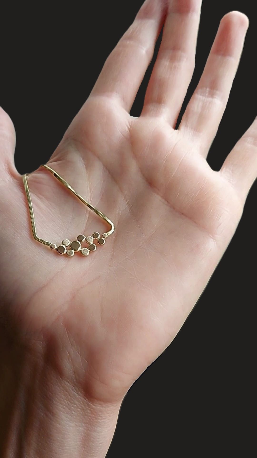  gouden ketting met druppelvormige compositie in het midden. mat en glanzend afgewerkt. 