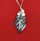 Zilveren hanger ketting donkere blisterparel met halve bollen.