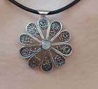 Zilveren filigraan bloemenhanger aan een zwart koordketting. met rosekwarts