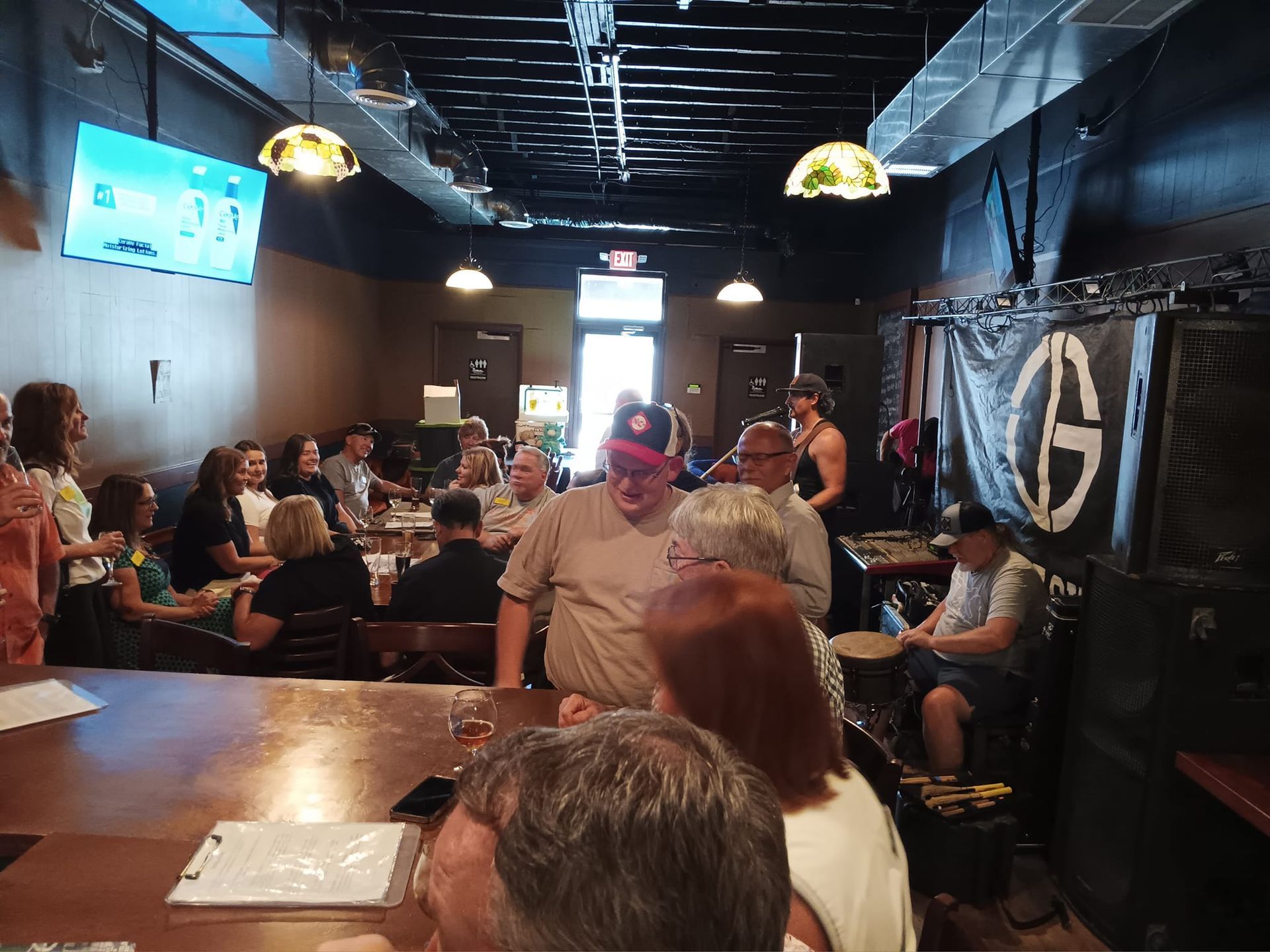 A group of people are sitting at tables in a restaurant.