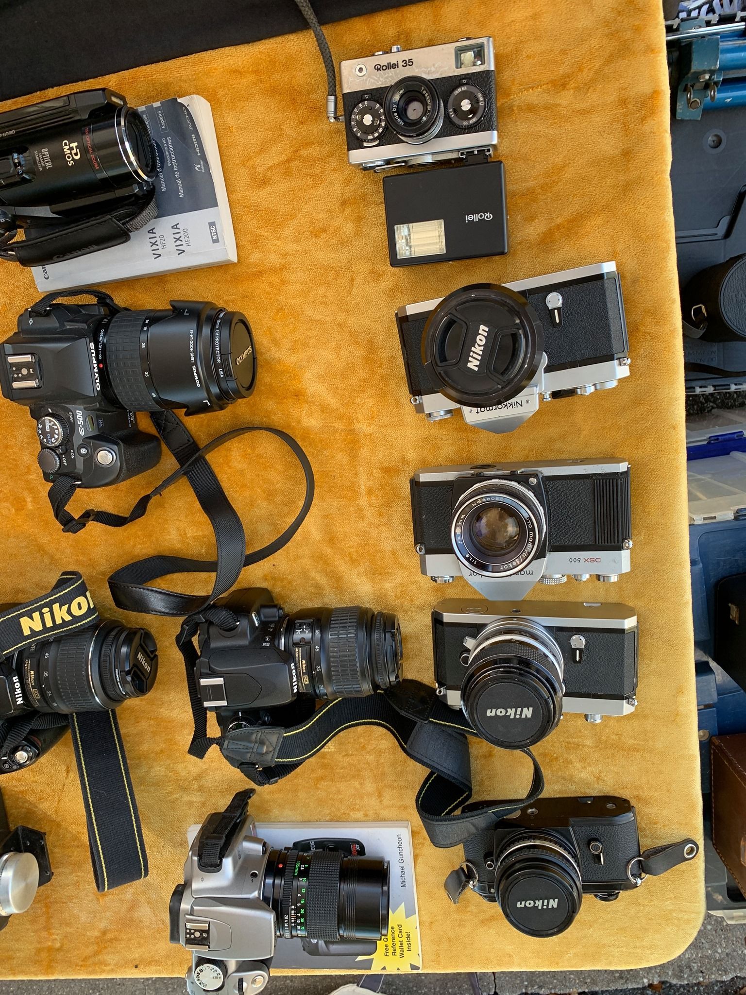 Several vintage film cameras arranged on an orange cloth, viewed from above