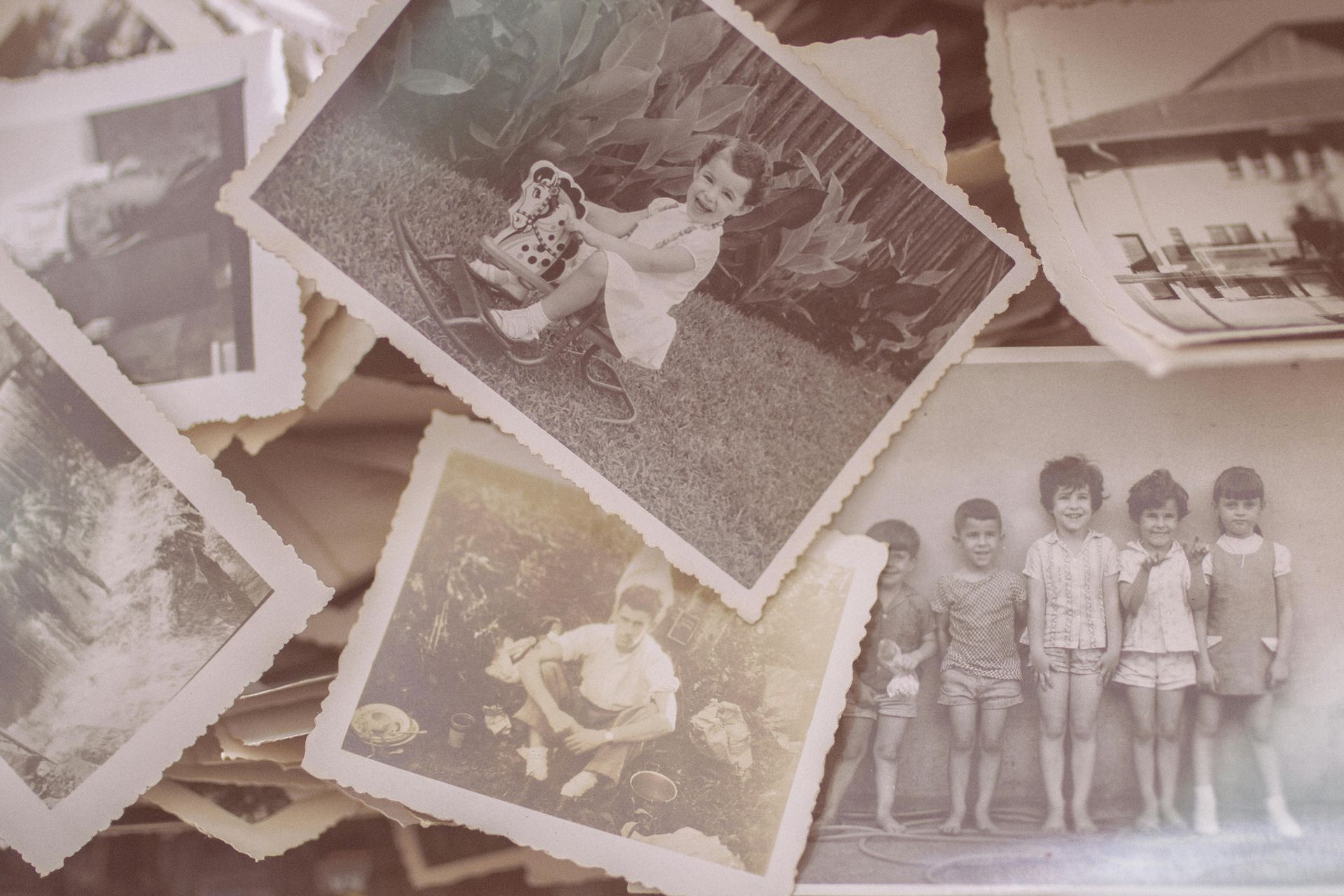 Scattered vintage black-and-white family photos on a faded pink background