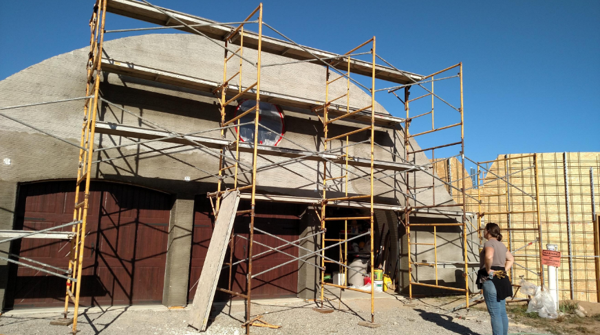 “Building exterior surrounded by scaffolding while workers complete stucco installation during a stucco service in Henderson, NV”