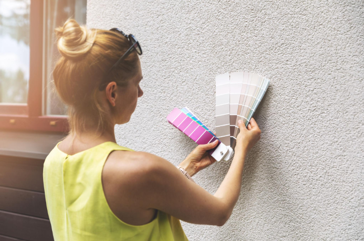 “Worker using a trowel to apply stucco texture around a window on a home exterior during a stucco service in Henderson, NV”