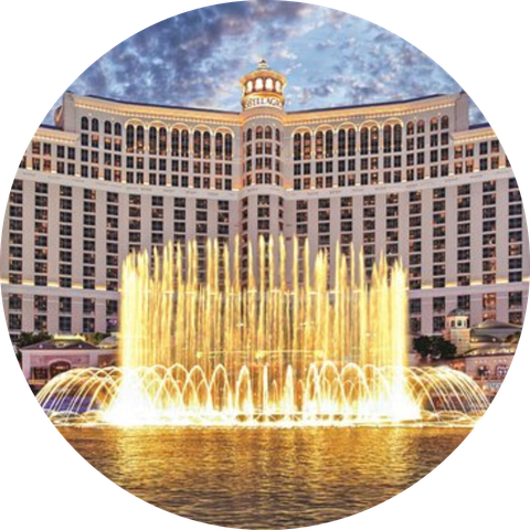 Bellagio hotel fountain show at dusk with bright golden water jets in front of the resort