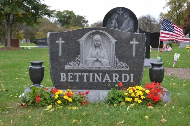 A grey, carved headstone with the name 