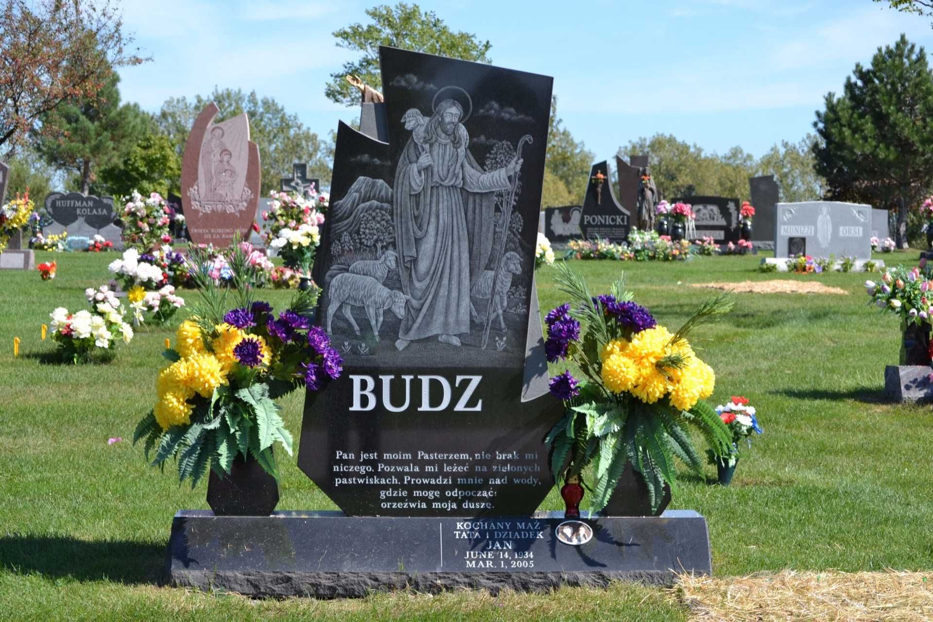 A black granite headstone with an etching of a shepherd, engraved with 