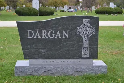 A dark gray polished granite headstone engraved with 