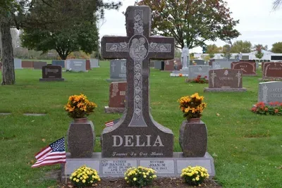 A large cross-shaped granite headstone marked 