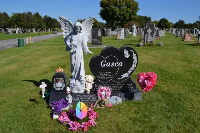 A heart-shaped black granite gravestone labeled 