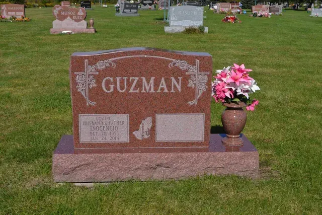 A red granite headstone inscribed 