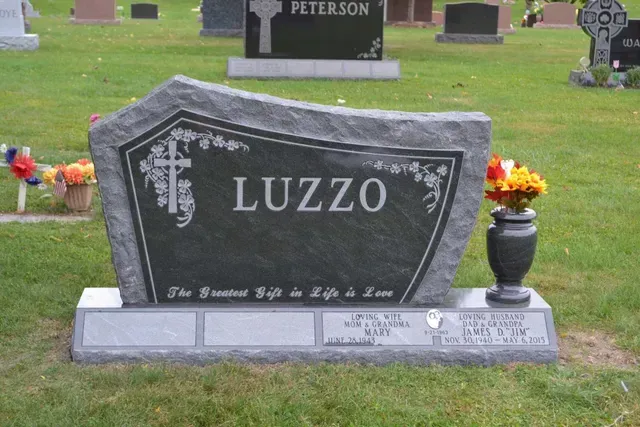 A dark gray granite tombstone engraved with 