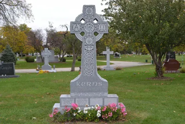 A gray granite Celtic cross headstone inscribed with 