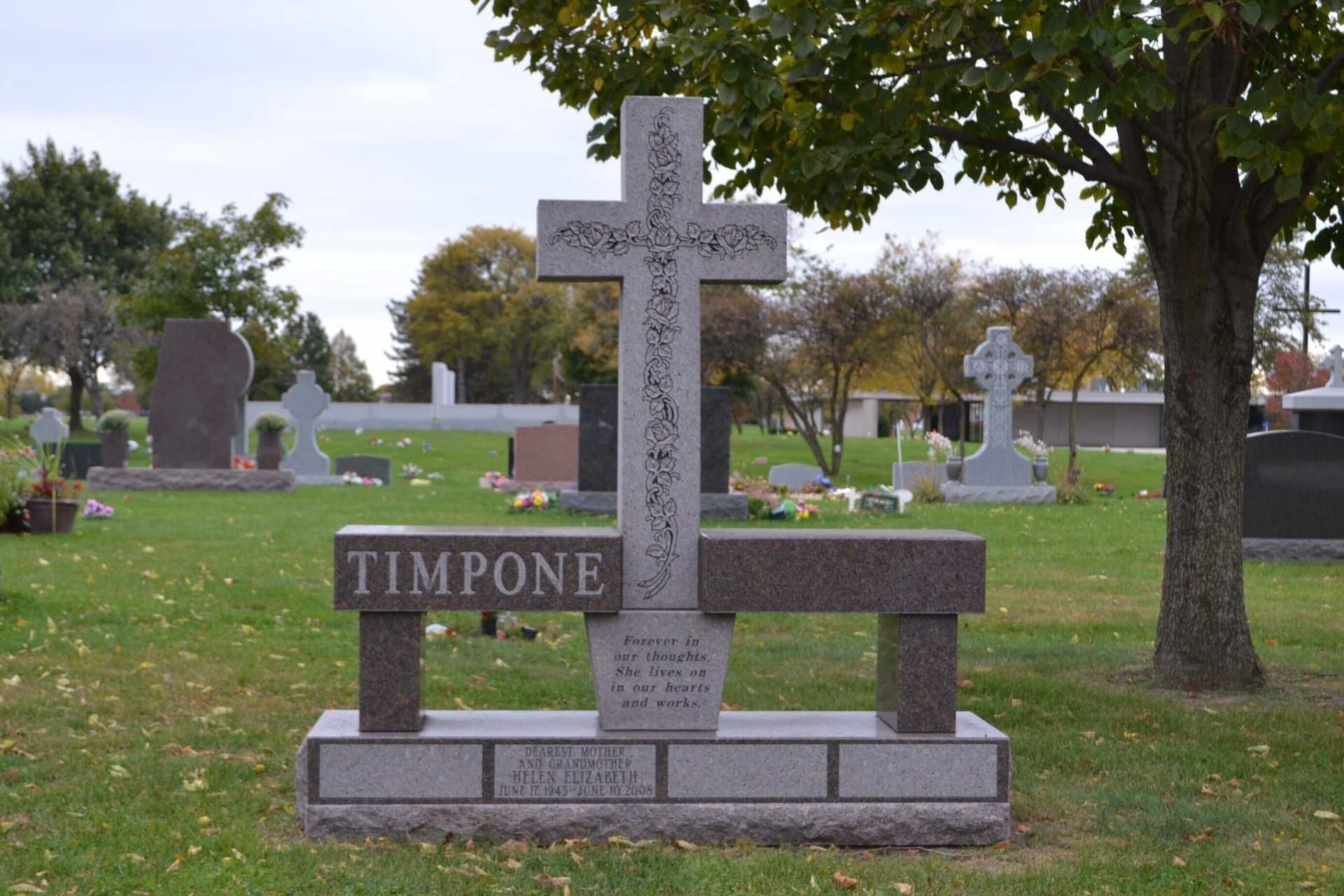 Gravestone with cross design, bench, and name 