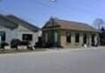Two buildings with angled roofs and multiple windows, likely a business or residence on a street.