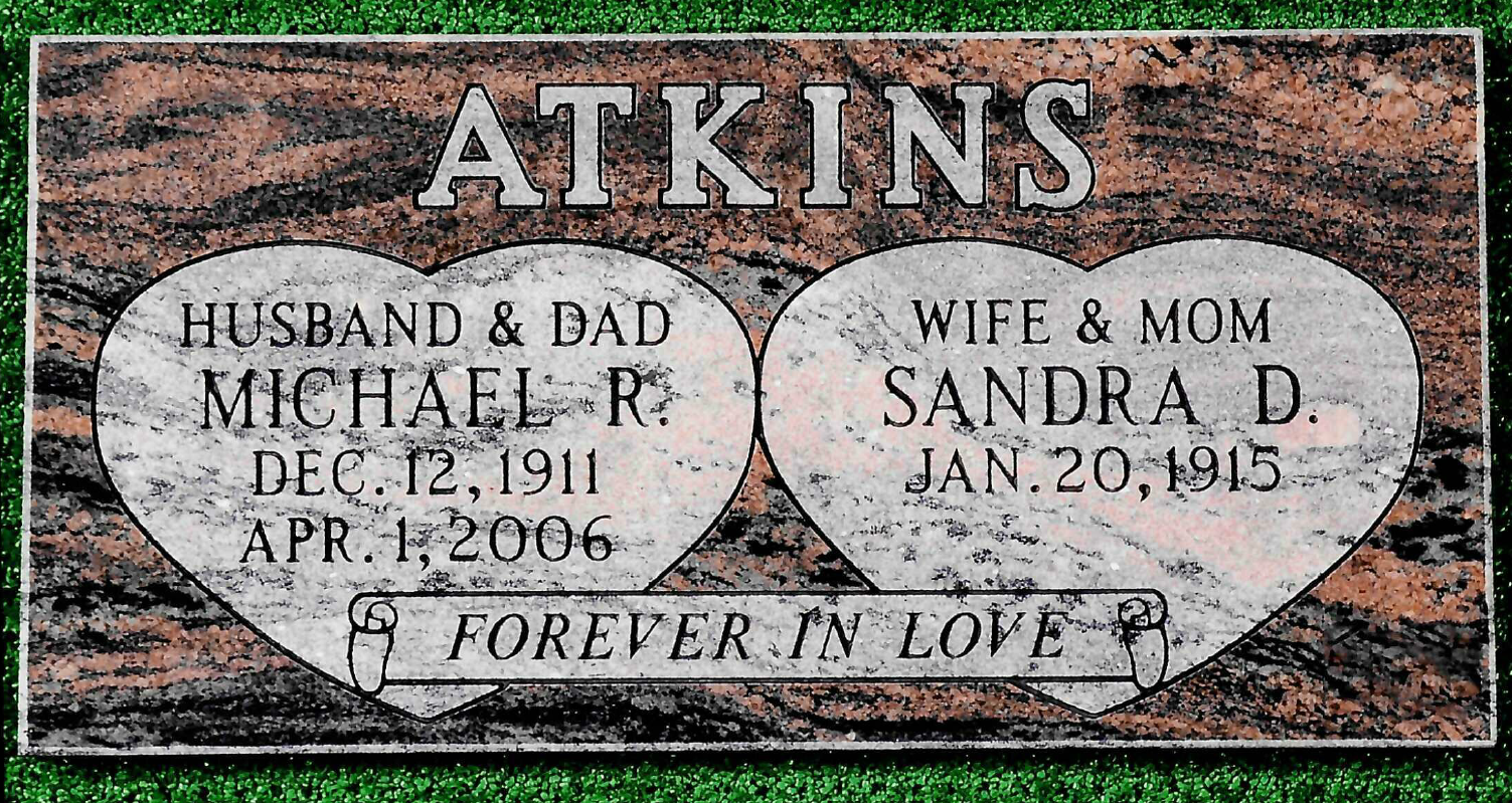 A granite grave marker for Michael R. and Sandra D. Atkins, inscribed with