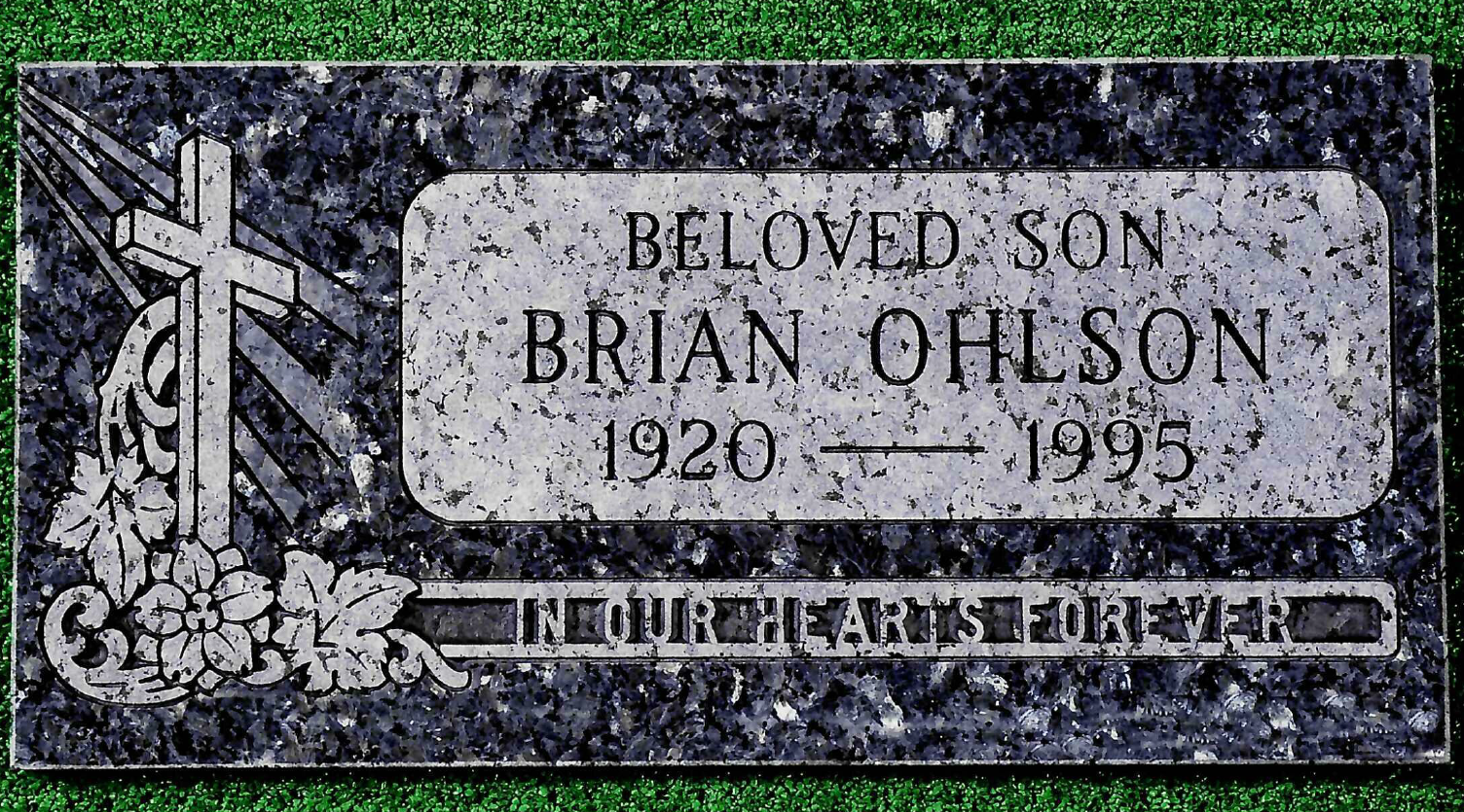 A dark grey granite headstone marked with a cross engraving and the text