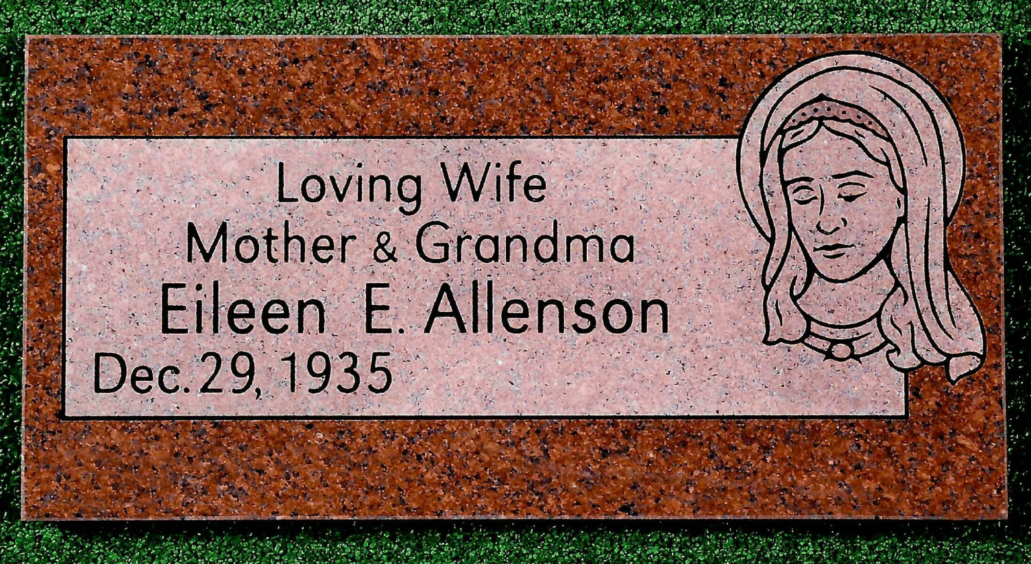 A red granite rectangular memorial marker engraved with