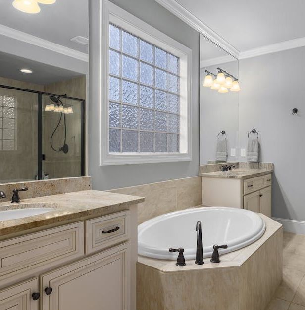 A bathroom with a tub a sink and a window