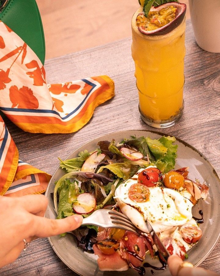Uma pessoa está comendo uma salada em um prato com um garfo. 