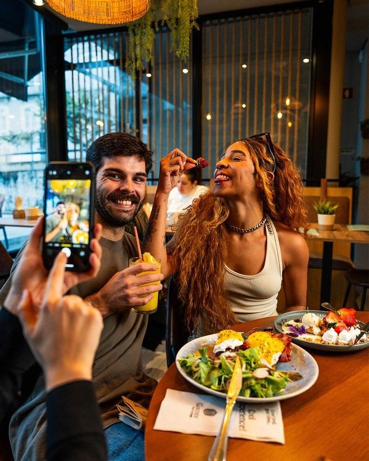 Um homem e uma mulher estão sentados à mesa com pratos de Brunch
