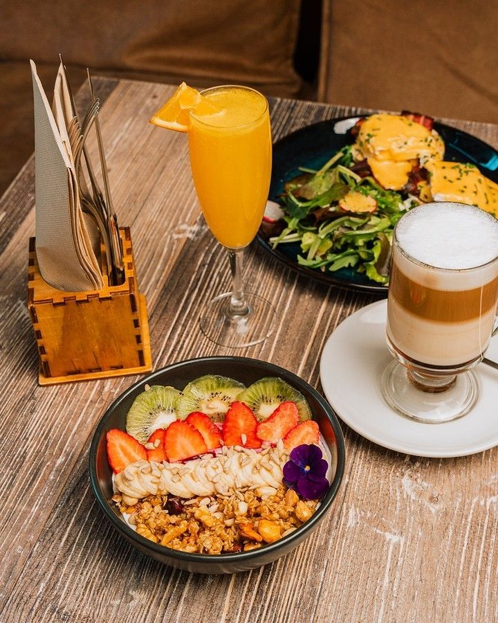 Uma mesa de madeira com pratos e bebidas de Brunch servidos a mesa