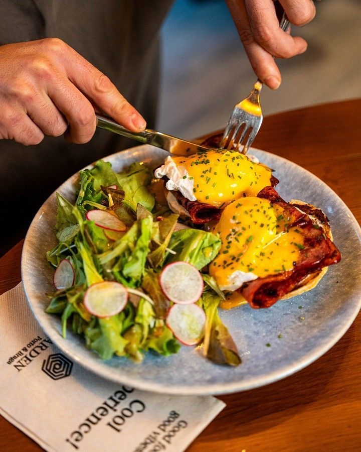 Uma pessoa corta um prato de comida com um garfo, prato típico de um brunch