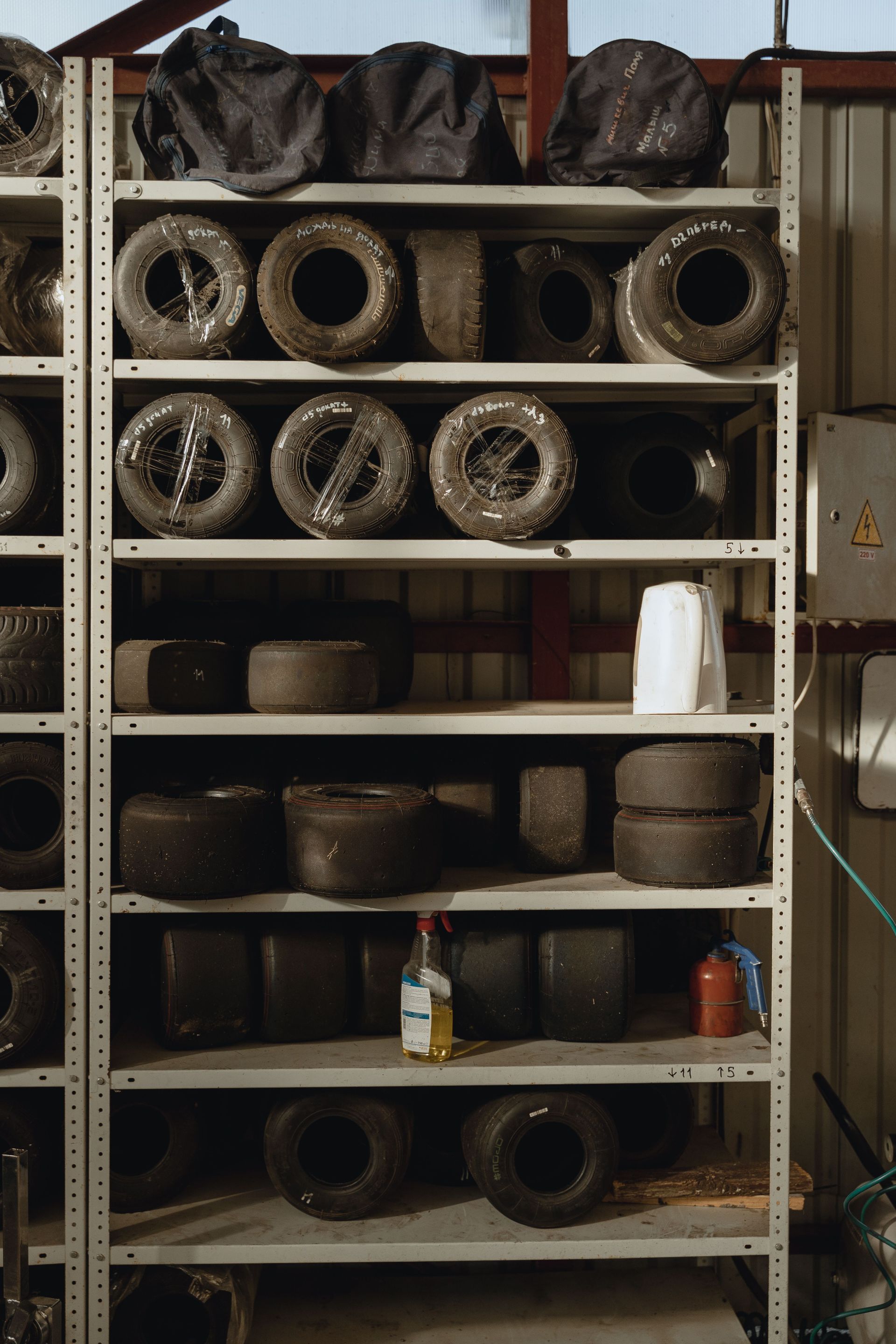 Shelf of old tires and rims in a workshop storage area