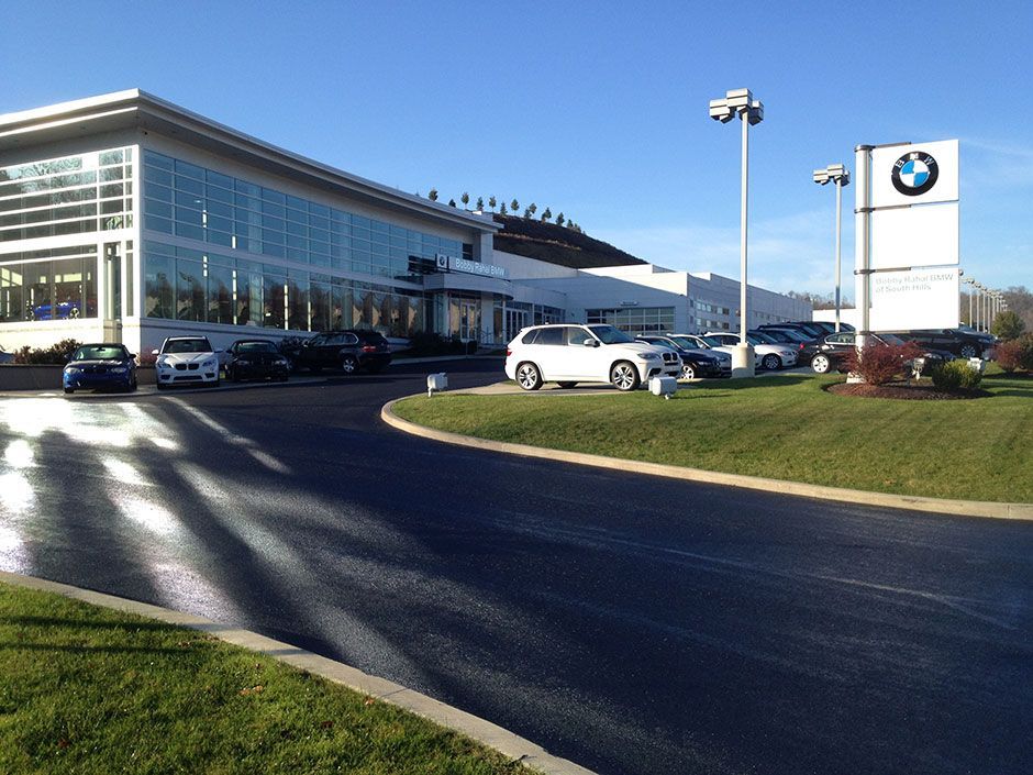 BMW dealership building with parked cars on a sunny day