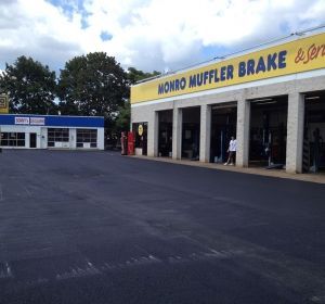 Auto repair shop with yellow Monroe Muffler Brake sign and empty parking lot