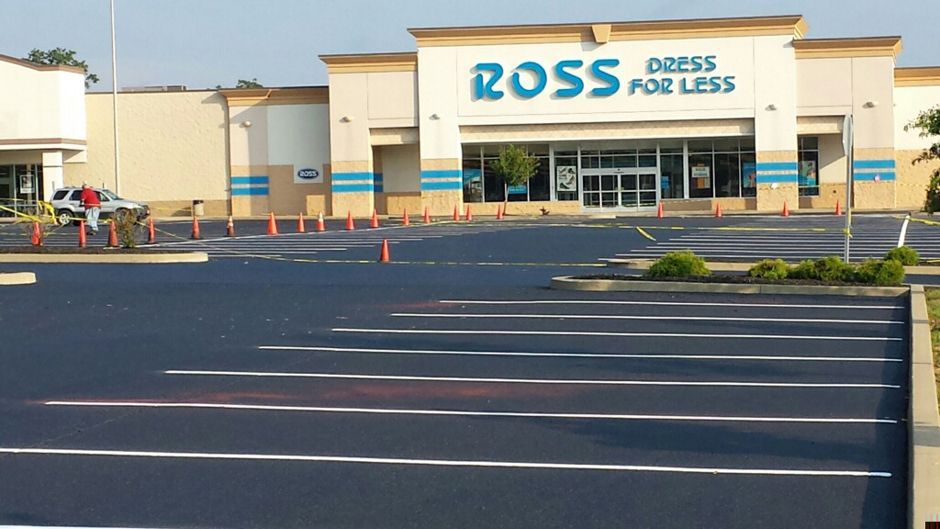 Ross Dress for Less storefront with empty parking lot in front, seen on a sunny day