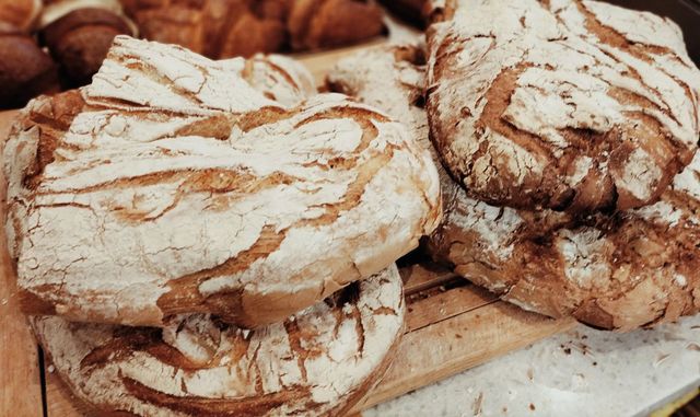 Pila di biscotti rustici ricoperti di zucchero a velo su un vassoio di legno.